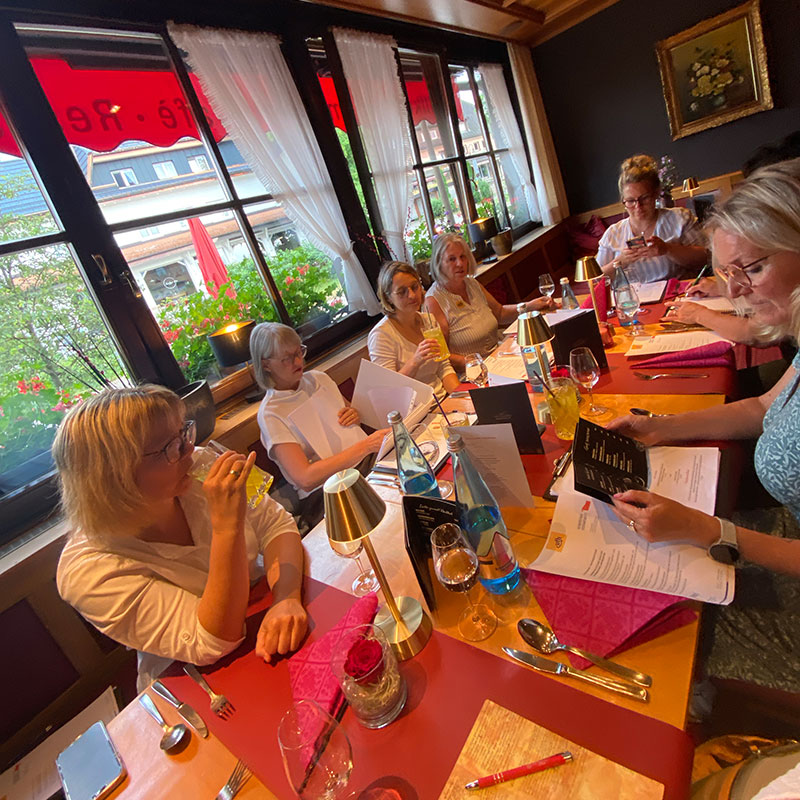 Gruppe sitz am Tisch und schaut in die Speisekarte um essen zu bestellen